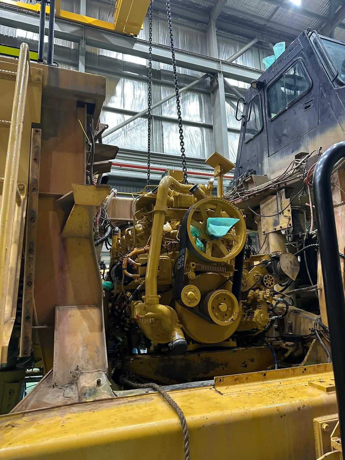 Engine being lifted into a dozer chassis in the workshop