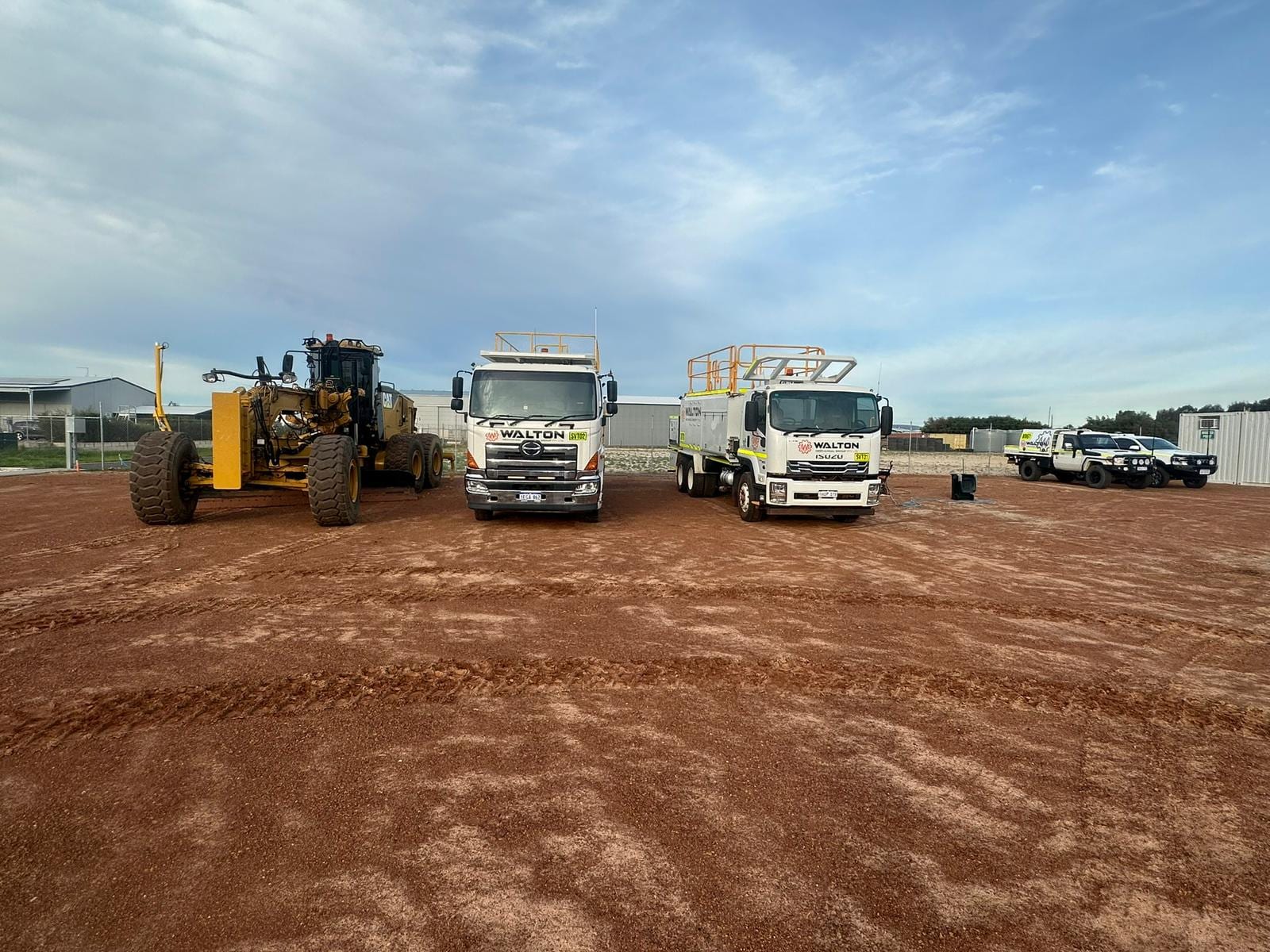 Walton Mechanical Group grader and fitted service trucks lined up on a WA site