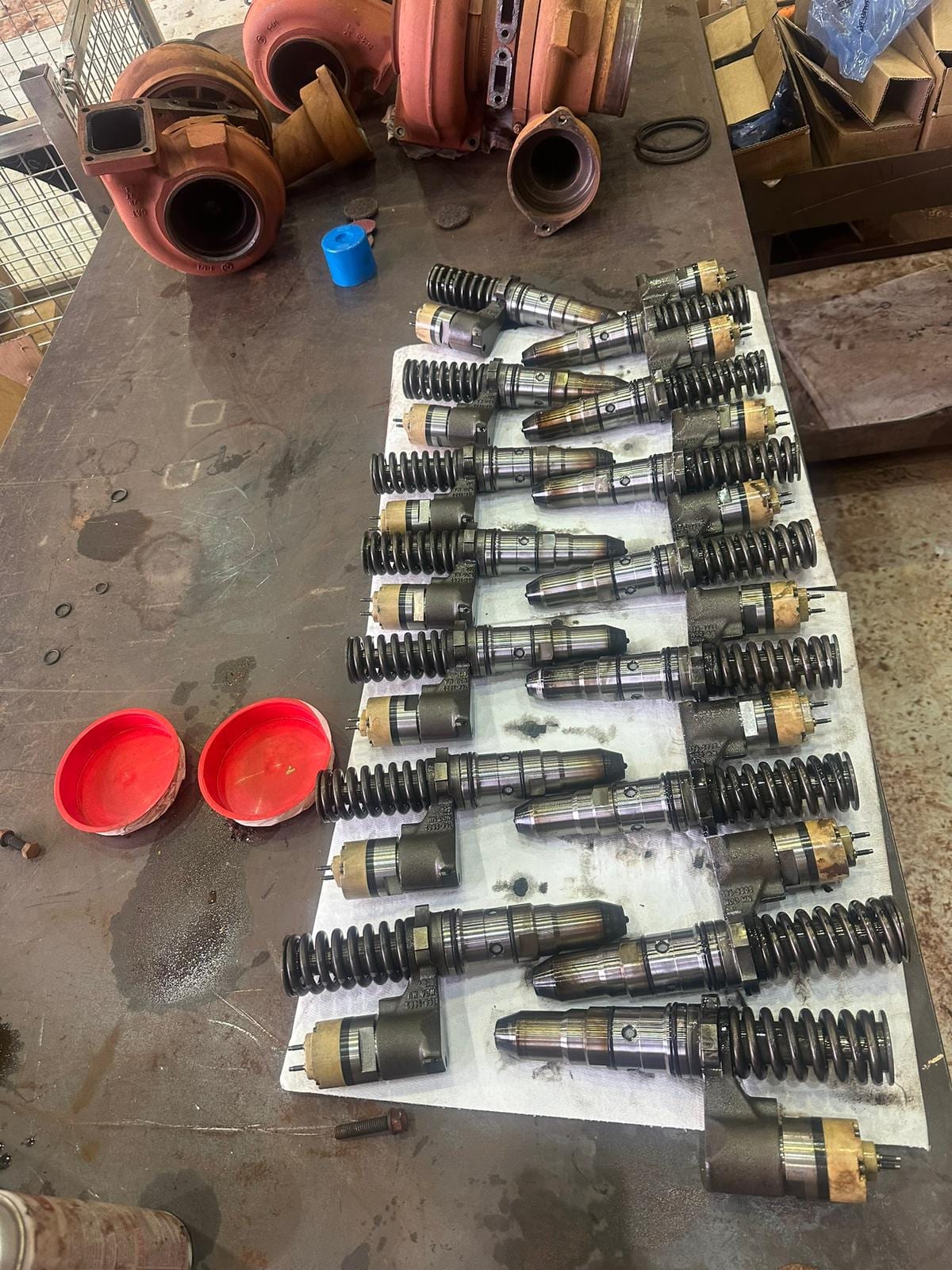 Injector and engine components laid out on a workshop bench